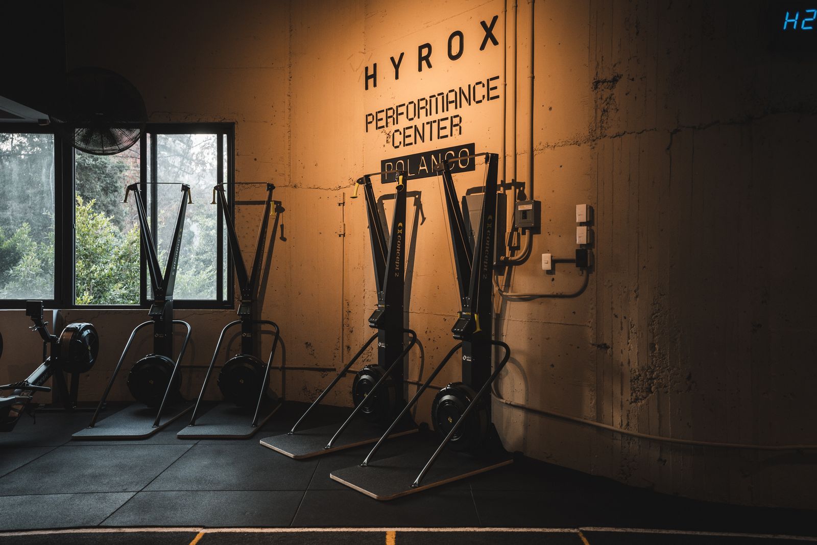 Letrero del HYROX Performance Center con equipos de ski y remo