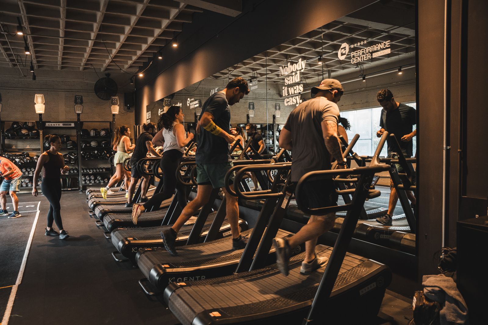 Atletas entrenando en caminadoras curvas en el HYROX Performance Center